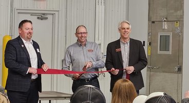 John Marshal holds a ribbon to the left, Dean Brian Buhr holds a ribbon to the right, SPRF Ron Faber stands in the middle with a large scissors to cut the ribbon.